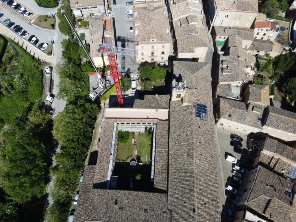 Veduta aerea del monastero di San Marco a Offida con il chiostro centrale, i tetti e la gru di cantiere